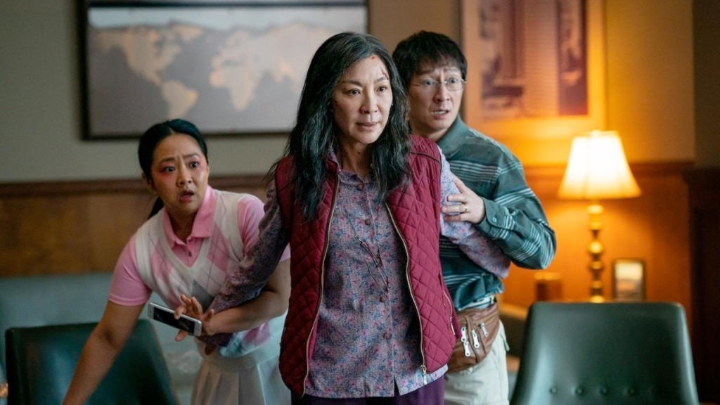 Evelyn (Michelle Yeoh) pushing her husband Waymond (Ke Huy Quan) and her daughter Joy (Stephanie Hsu) behind her. 