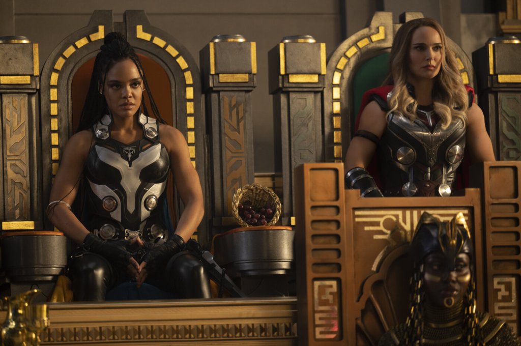 Valkyrie (Tessa Thompson) and Jane as Thor (Natalie Portman) sitting on thrones.