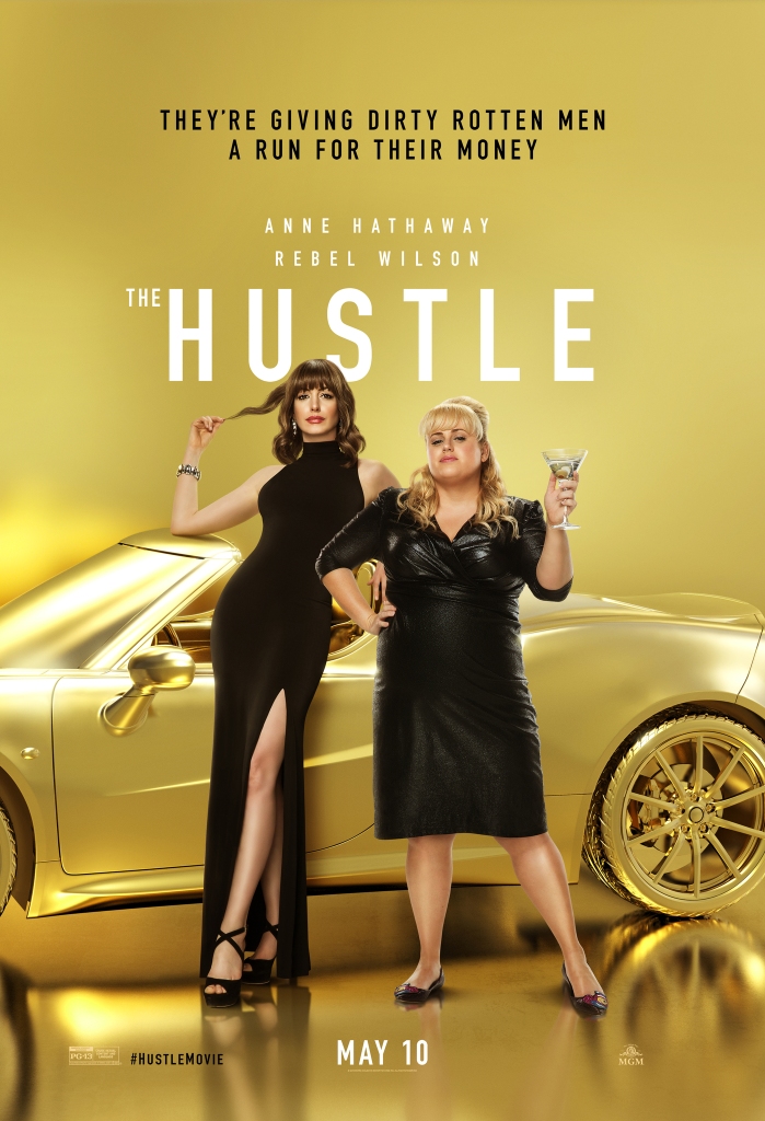 The film poster showing Josephine (Anne Hathaway) and Penny (Rebel Wilson) standing in front of a golden car in fancy black dresses.